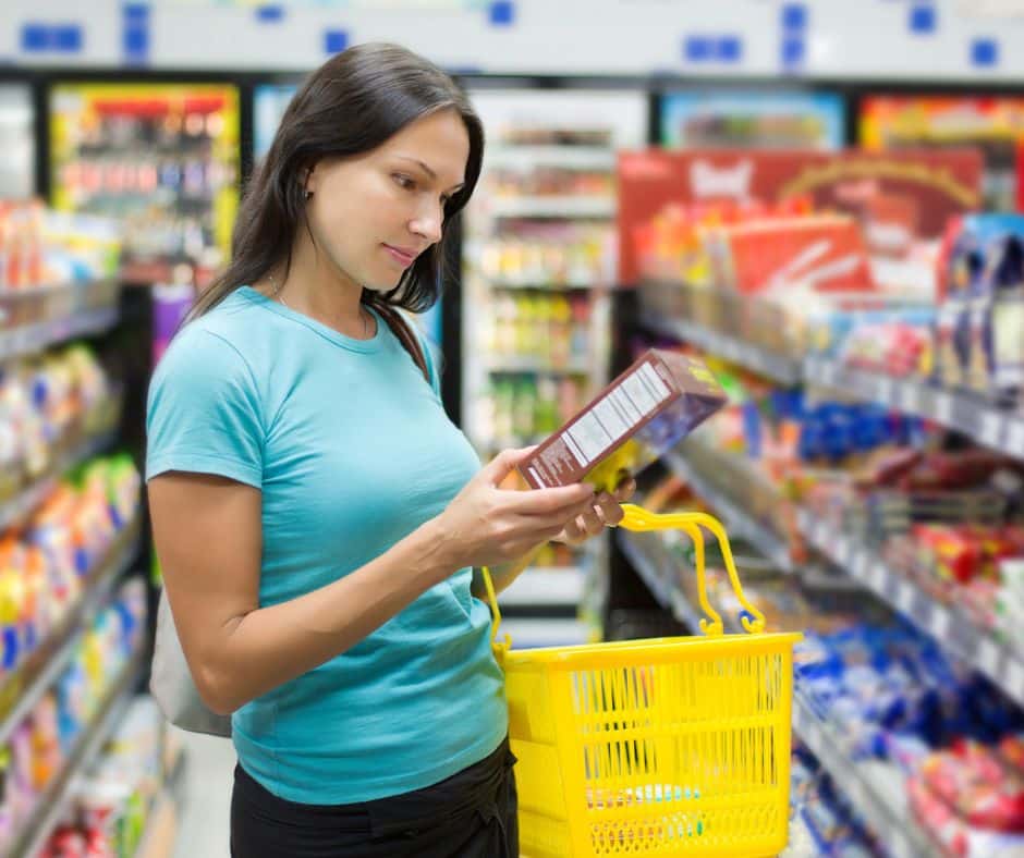 come leggere le etichette al supermercato donna che sfoglia un prodotto in corsia